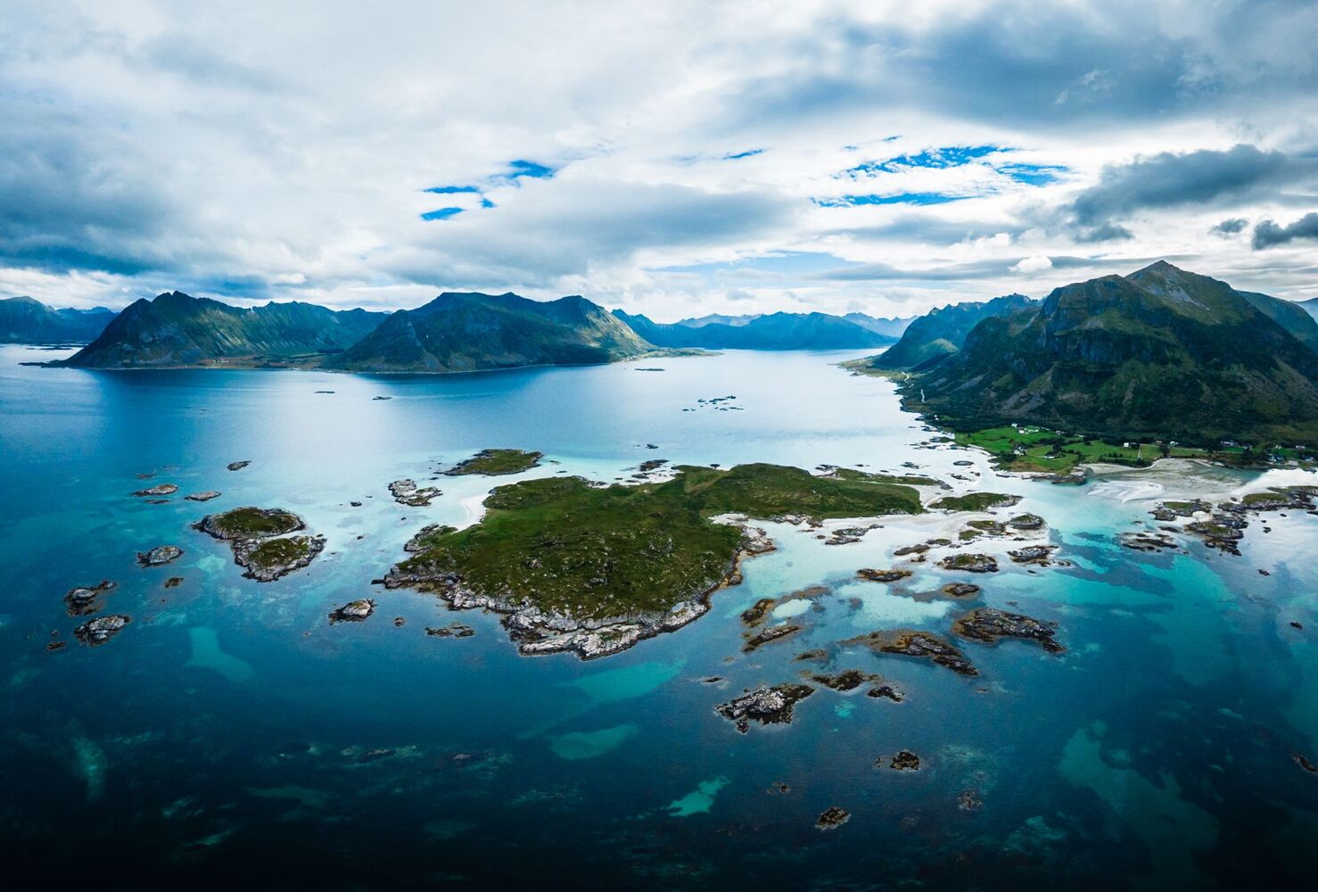 Kleine Inseln in türkisem Wasser vor Bergen, von oben